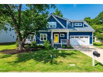 Charming two-story blue home with a bright yellow front door and well-manicured lawn at 405 Culvert St, Apex, NC 27502