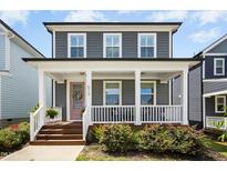 Charming two-story home with a welcoming front porch and a pink door at 513 Basin Hill Dr, Wake Forest, NC 27587