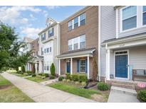 Inviting exterior view of townhomes, showcasing their brick facade and well-manicured lawns on a bright day at 6107 Kayton St, Raleigh, NC 27616