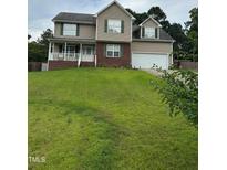 Charming two-story home with a manicured lawn, two car garage, and welcoming front porch at 642 Pinevalley Ln, Sanford, NC 27332