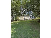 Charming traditional home with lush green lawn, mature trees, and well-maintained landscaping at 7140 N Ridge Dr, Raleigh, NC 27615