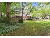 Traditional two-story home with an inviting front yard and a charming American flag waving in the breeze at 7209 St Ledger Dr, Raleigh, NC 27613