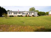 Charming single-story home with a well-manicured lawn and an American flag at 764 Olivers Grove Rd, Four Oaks, NC 27524