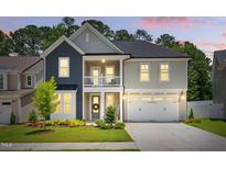 Charming two-story home with a welcoming front porch, beautiful landscaping, and two-car garage at 9120 Dupree Meadow Dr, Angier, NC 27501