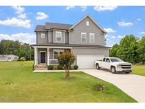 Charming two-story home with gray siding, manicured lawn, and attached garage at 100 Arrowtown Way, Kenly, NC 27542