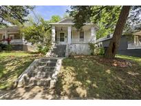 Charming home with a inviting front porch and mature trees surrounding the property at 1022 Dorothea Dr, Raleigh, NC 27603