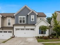 Charming two-story home with a white garage door and blue accent siding, well manicured lawn, and sunny day at 1038 Felman Rd, Durham, NC 27703