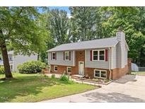 Charming split-level home featuring gray siding, brick accents, and a well-maintained front yard at 105 Otter Dr, Cary, NC 27513