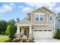 Charming two-story home with a two-car garage, covered porch, stone accents, and well-maintained landscaping at 137 Azalea View Way, Holly Springs, NC 27540