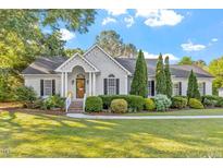 Charming home featuring manicured landscaping, a well-maintained lawn and elegant front entry with classic architectural details at 1819 Umstead Rd, Durham, NC 27712