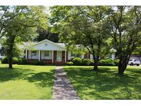 Charming single-story brick home with a well-manicured front yard and mature trees at 2071 Meadow Ln, Graham, NC 27253