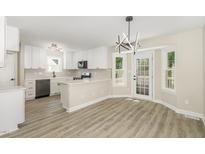 This spacious kitchen features modern appliances, white cabinets, light gray backsplash, and bright natural light at 2324 Dahlgreen Rd, Raleigh, NC 27615