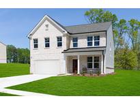 Stunning two-story home boasts a classic brick facade, attached garage, and well-manicured lawn under a clear blue sky at 242 Macon Lake Drive # 37, Apex, NC 27523