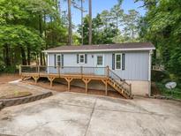 Charming home featuring a wooden deck, light blue siding, and mature trees surrounding the property at 2704 Shaftsbury St, Durham, NC 27704