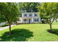Charming two-story home featuring a well-manicured front lawn and classic white exterior with black shutters at 2817 Henslowe Dr, Raleigh, NC 27603