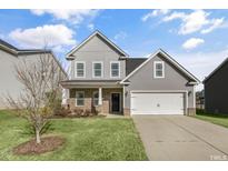 Charming two-story home with gray siding, brick accents, and a well-manicured lawn at 32 Iroquois Ct, Garner, NC 27529