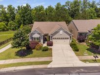 Charming single-story home featuring a well-manicured lawn and a two-car attached garage at 323 Rosedale Creek Dr, Durham, NC 27703