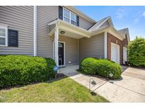 Inviting townhome entrance featuring manicured landscaping, classic architecture, and a secure ADT system at 3526 Londonville Ln, Raleigh, NC 27604