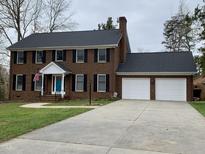 Charming brick two-story home with a spacious driveway and a two-car garage at 408 Greenfern Ct, Burlington, NC 27215