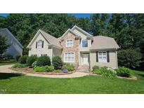 Charming two-story home with stone accents, manicured lawn, and lush landscaping at 4305 Heathgate Ln, Raleigh, NC 27613