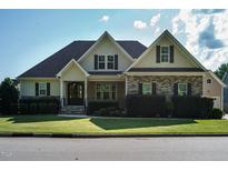 Charming home with a stone and siding exterior, manicured lawn, and welcoming front porch at 5305 Yorkville Ct, Holly Springs, NC 27540
