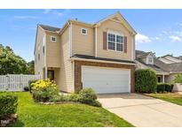 Charming two-story home with an attached garage and well-manicured lawn and colorful flower bed at 5561 Roan Mountain Pl, Raleigh, NC 27613