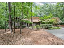 Charming single-story home with a wooded front yard and a concrete driveway at 6 Womble Cir, Durham, NC 27705