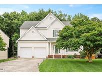 Charming two-story home boasts a manicured lawn, two-car garage, and lovely landscaping at 615 Southshore Pkwy, Durham, NC 27703