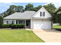 Charming single-story home featuring a two-car garage and well-maintained landscaping in a suburban setting at 70 Dexterfield Dr, Fuquay Varina, NC 27526