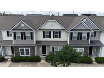 A beautiful townhouse featuring stone accents, neutral siding, and a well-maintained front yard at 711 Keystone Park Dr # 78, Morrisville, NC 27560