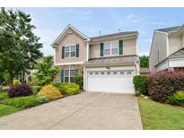 Charming two-story home featuring a stone accent facade, well-maintained landscaping, and a two-car garage at 7873 Cape Charles Dr, Raleigh, NC 27617