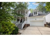 Charming two-story home with a double porch, two-car garage, and lush landscaping at 804 Town Side Dr, Apex, NC 27502