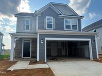 Charming two-story home with a two-car garage and stone details, offering modern curb appeal at 88 Willow Cameron Way, Angier, NC 27501