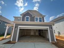 Two-story gray home with an open garage and a traditional style with a symmetrical window design at 88 Willow Cameron Way, Angier, NC 27501