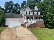 Charming two-story home with a covered front porch and a two-car garage at 109 Hidden Farm Ln, Holly Springs, NC 27540