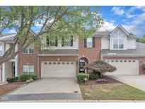 Charming townhome featuring a brick facade, attached garage, and well-manicured landscaping at 12227 Orchardgrass Ln, Raleigh, NC 27614