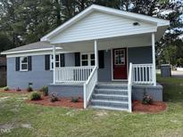 Charming single-story home with a red front door, landscaped yard, and freshly painted exterior at 1225 Gay St, Rocky Mount, NC 27804
