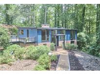 Beautiful two-story home with blue siding, brick accents and large windows in a serene wooded setting at 19 Learned Pl, Durham, NC 27705