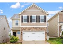 Charming two-story home featuring a stone-accented facade, neutral siding, and a two-car garage at 212 Sea Trail St, Hillsborough, NC 27278
