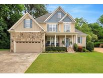 Charming two-story home with stone accents, inviting porch, and well-manicured lawn at 218 Kinvara Ct, Wake Forest, NC 27587