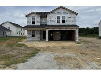 New construction home featuring an unfinished front yard and an attached two-car garage at 29 Chloe Ct, Selma, NC 27576