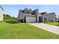 Charming two-story home with manicured lawn and a two-car garage on a sunny day at 404 Porterfield Dr, Youngsville, NC 27596