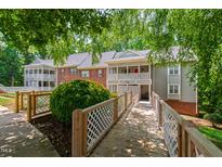 Inviting condo complex with a lush garden and bridge walkway to the units at 407 Gooseneck Dr # B1, Cary, NC 27513