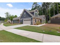 Charming home with a two-car garage, stone accents, manicured lawn and long drive way at 428 Crayton Oak Dr, Cary, NC 27519