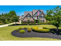 Beautiful two-story home featuring a stone facade, manicured landscaping, and an inviting front yard at 4621 Basilica Dr, Holly Springs, NC 27540
