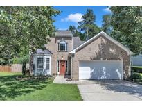 Charming brick two-story home featuring a two-car garage and lush landscaping at 5603 Whisperwood Dr, Durham, NC 27713