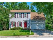 Charming two-story home featuring gray siding, a red door, and well-maintained landscaping at 6004 Solitude Way, Durham, NC 27713