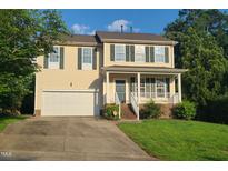 Charming two-story home features a two-car garage, welcoming front porch and a well-maintained lawn at 6701 Winding Arch Dr, Durham, NC 27713