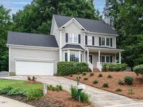 Charming two-story home with a manicured front yard, a two-car garage, and a welcoming porch at 9020 Branch Creek Way, Apex, NC 27539