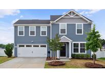 Charming two-story home featuring a two-car garage, black door, and well-manicured front yard at 1004 Summer Mist Ln, Durham, NC 27704